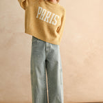 Full body view of city print casual sweater styled with jeans in Paris butter