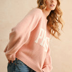Angled view of city print casual sweater in Paris pink for everyday wear