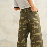 Close-up of Colette camouflage denim pants showing the stretch fabric, utility-inspired print, and raw hem detail.