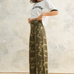 Side view of Colette camouflage wide leg denim pants with a relaxed fit, stretch denim fabric, and raw hem finish