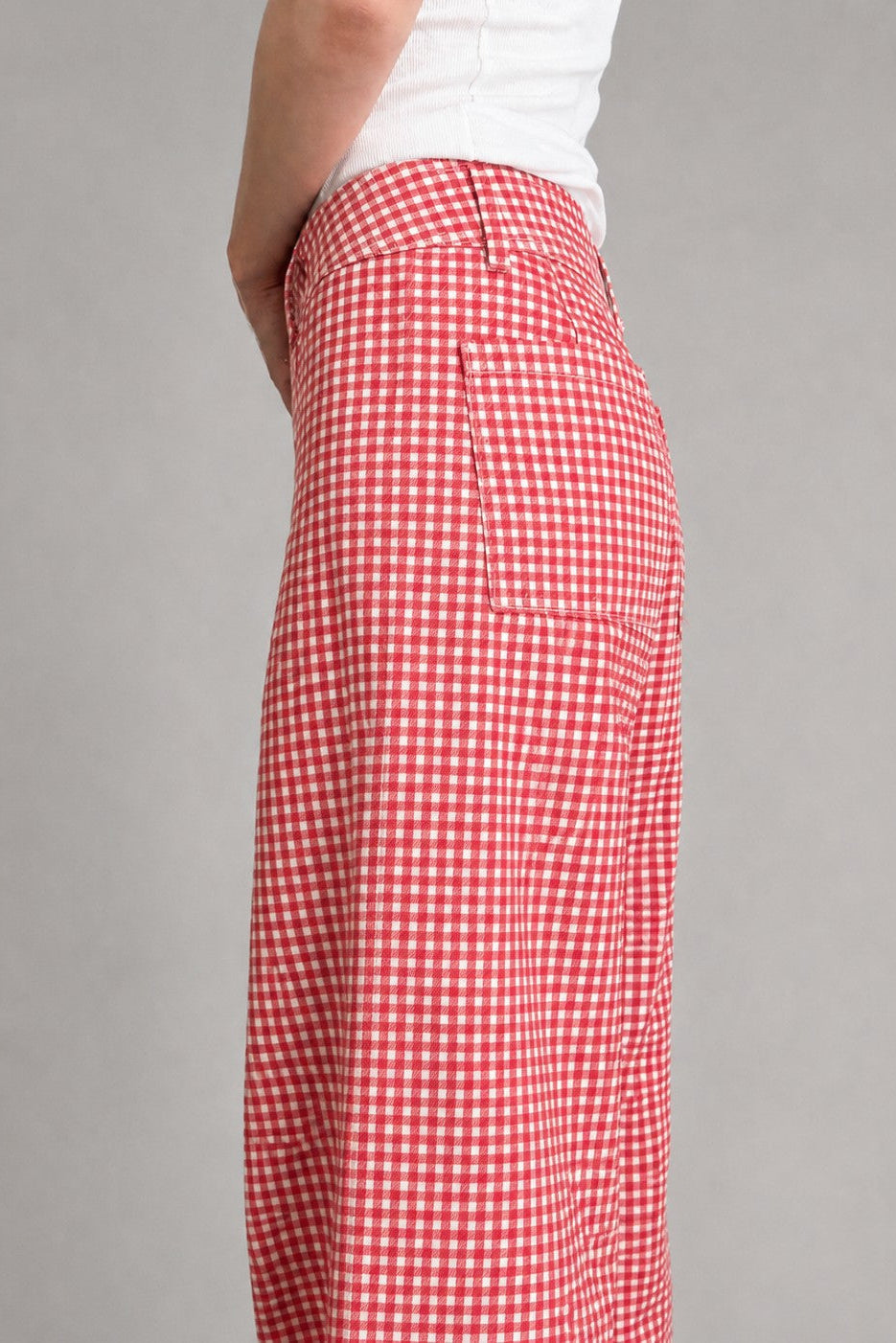 side view of Colette wide-leg gingham pants in red with a high-rise waist and raw hem - closer