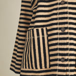 Close-up of striped pattern and patch pocket on cozy in stripes jacket in black combo
