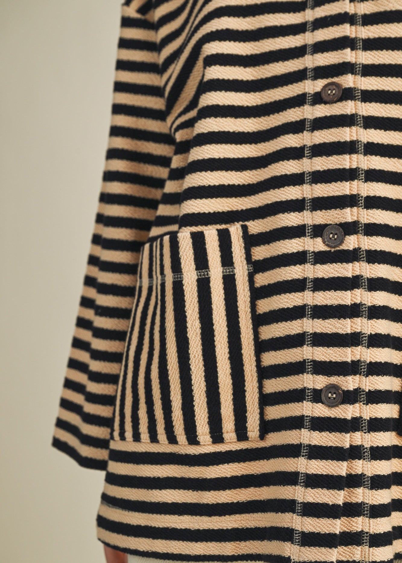 Close-up of striped pattern and patch pocket on cozy in stripes jacket in black combo