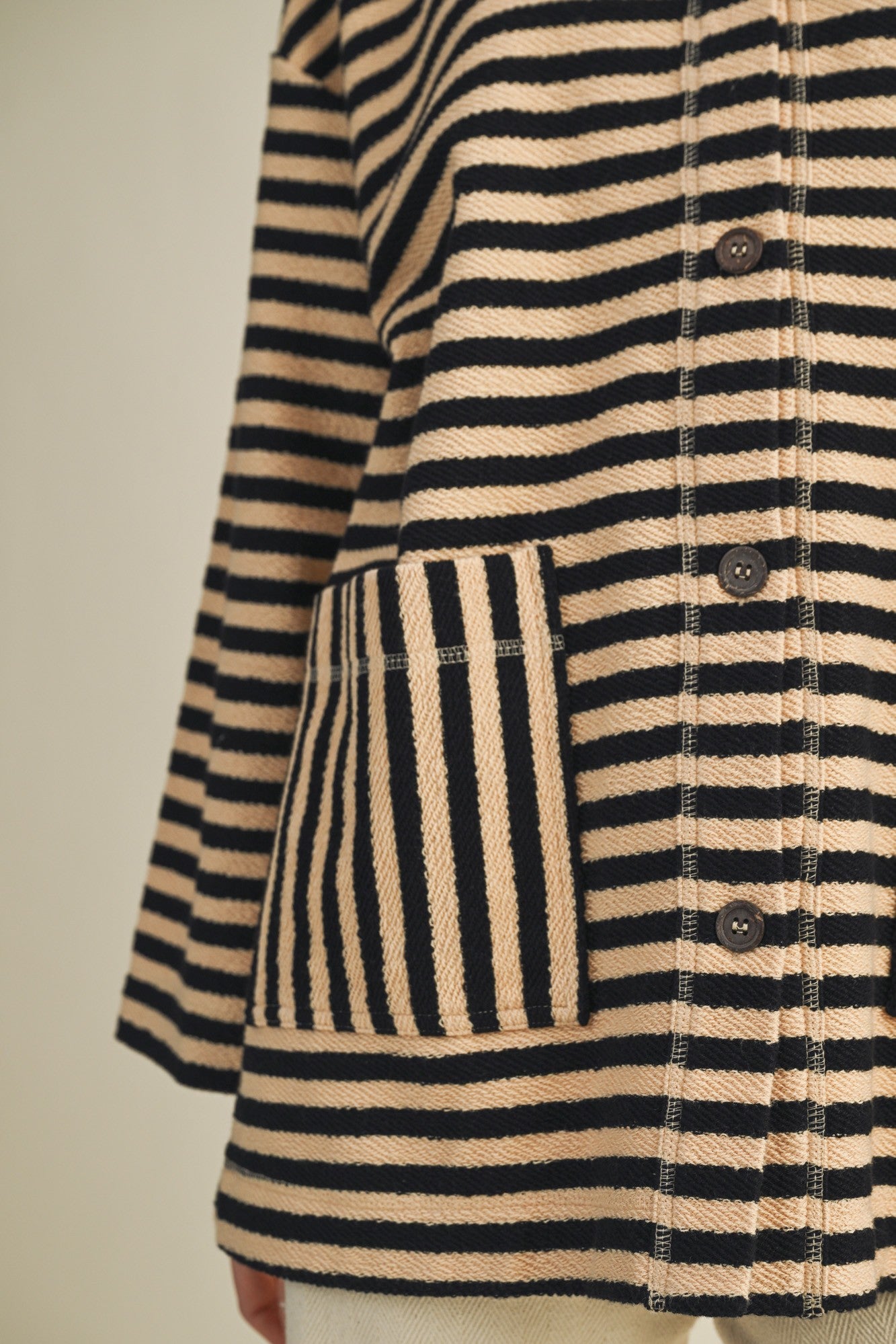 Close-up of striped pattern and patch pocket on cozy in stripes jacket in black combo
