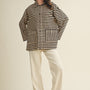 Full body view of cozy in stripes button-up jacket styled casually in black combo