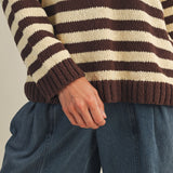 Close-up of striped knit texture on cozy v neck pullover in brown and ivory