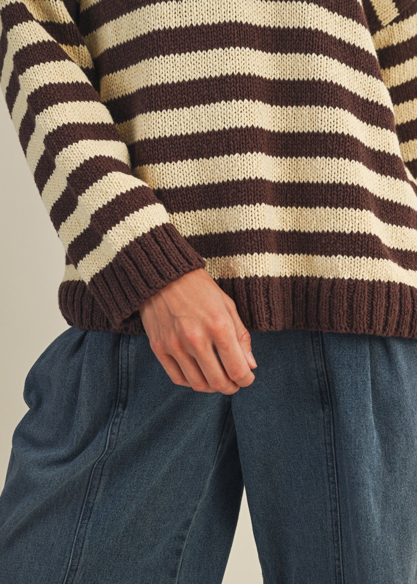 Close-up of striped knit texture on cozy v neck pullover in brown and ivory