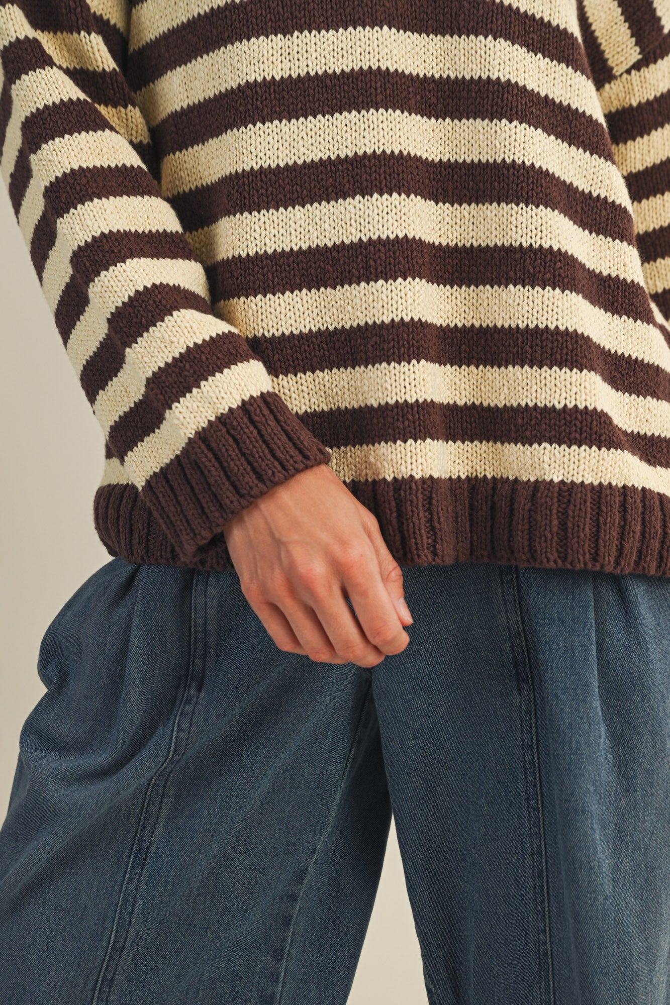 Close-up of striped knit texture on cozy v neck pullover in brown and ivory