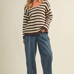 Full body view of cozy stripe v neck pullover styled with wide-leg jeans