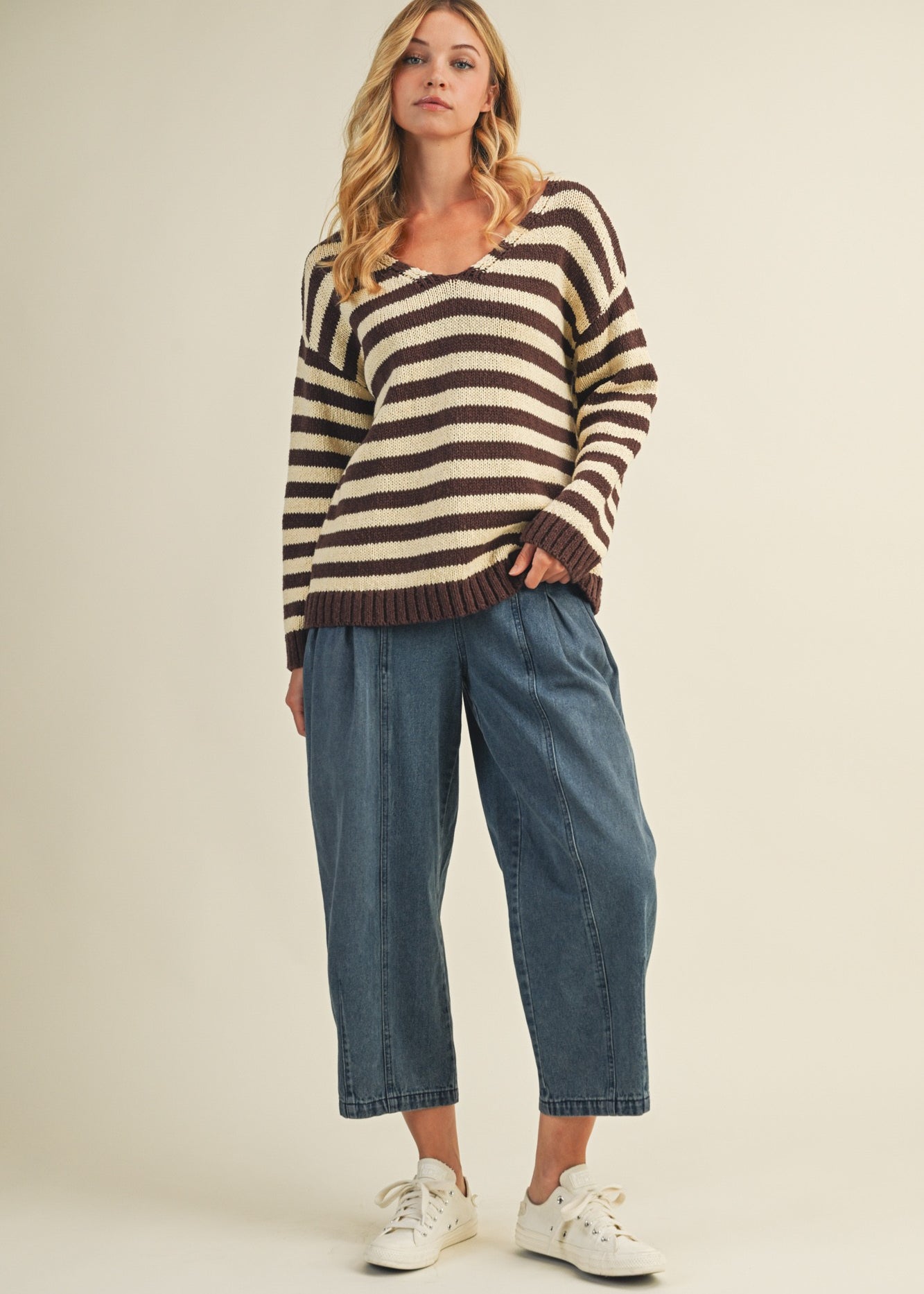 Full body view of cozy stripe v neck pullover styled with wide-leg jeans