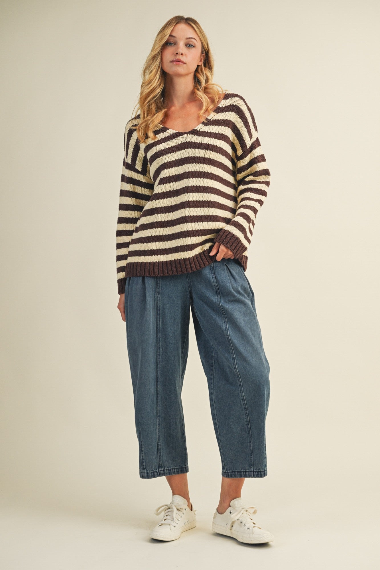 Full body view of cozy stripe v neck pullover styled with wide-leg jeans
