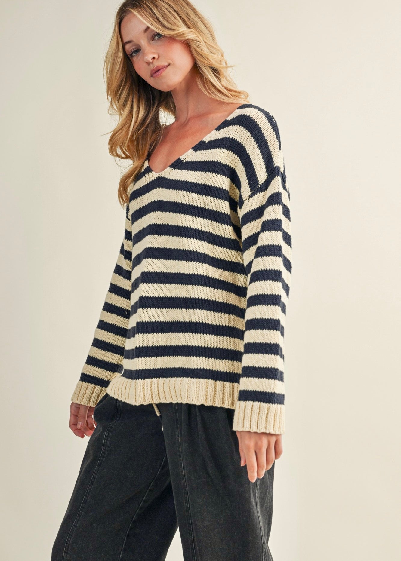 Angled front view of cozy stripe v neck pullover in navy and ivory