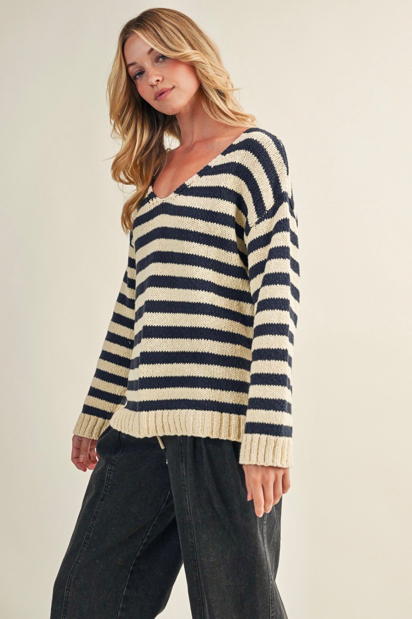 Angled front view of cozy stripe v neck pullover in navy and ivory