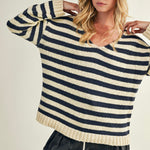 Woman wearing a striped sweater with a neutral background