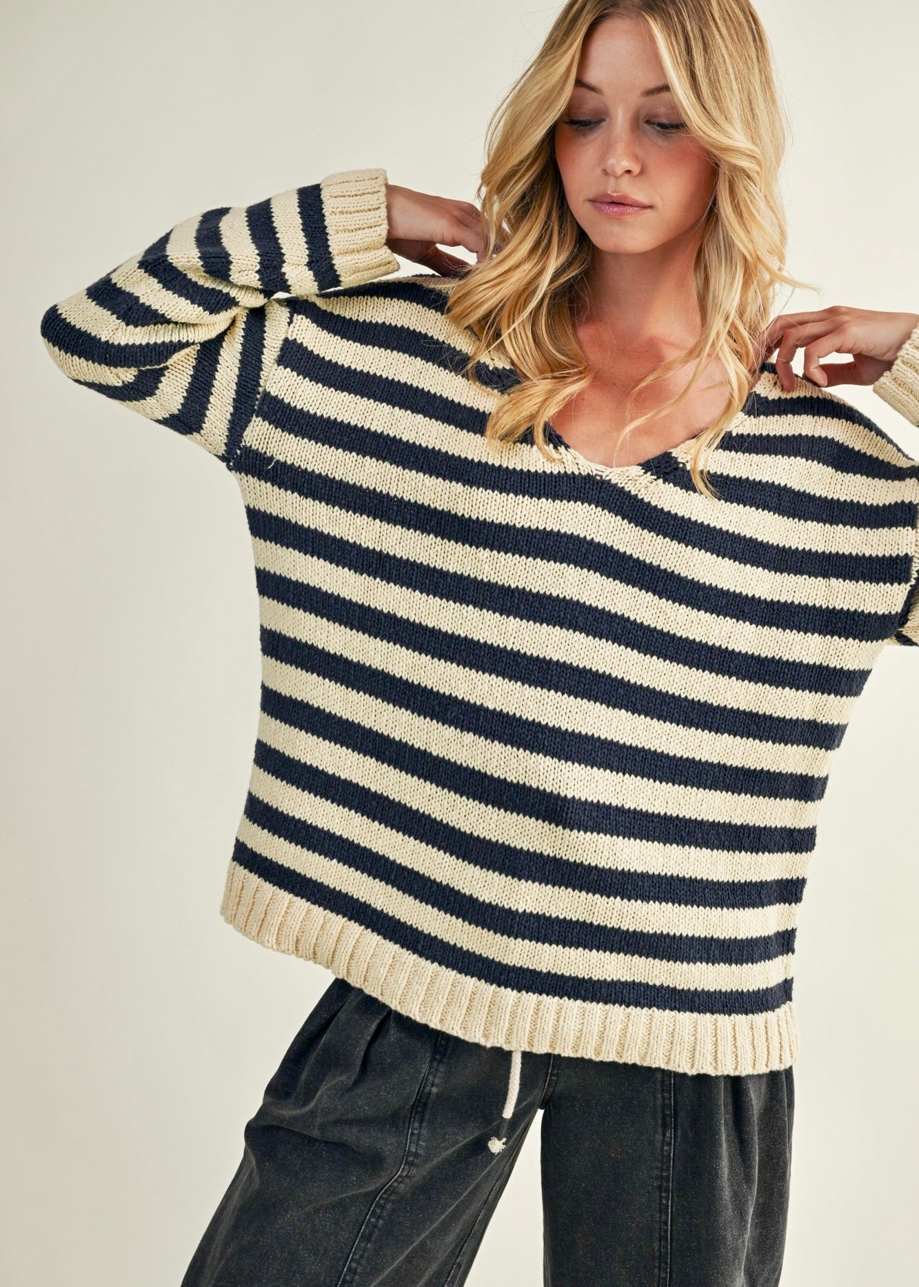 Woman wearing a striped sweater with a neutral background