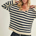 Woman wearing a striped sweater with a neutral background