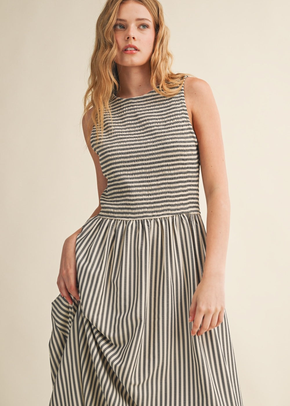 Close-up of Darcy Smocked Stripe Maxi Dress in black, featuring a textured smocked bodice, sleeveless design, and flowing striped maxi skirt.