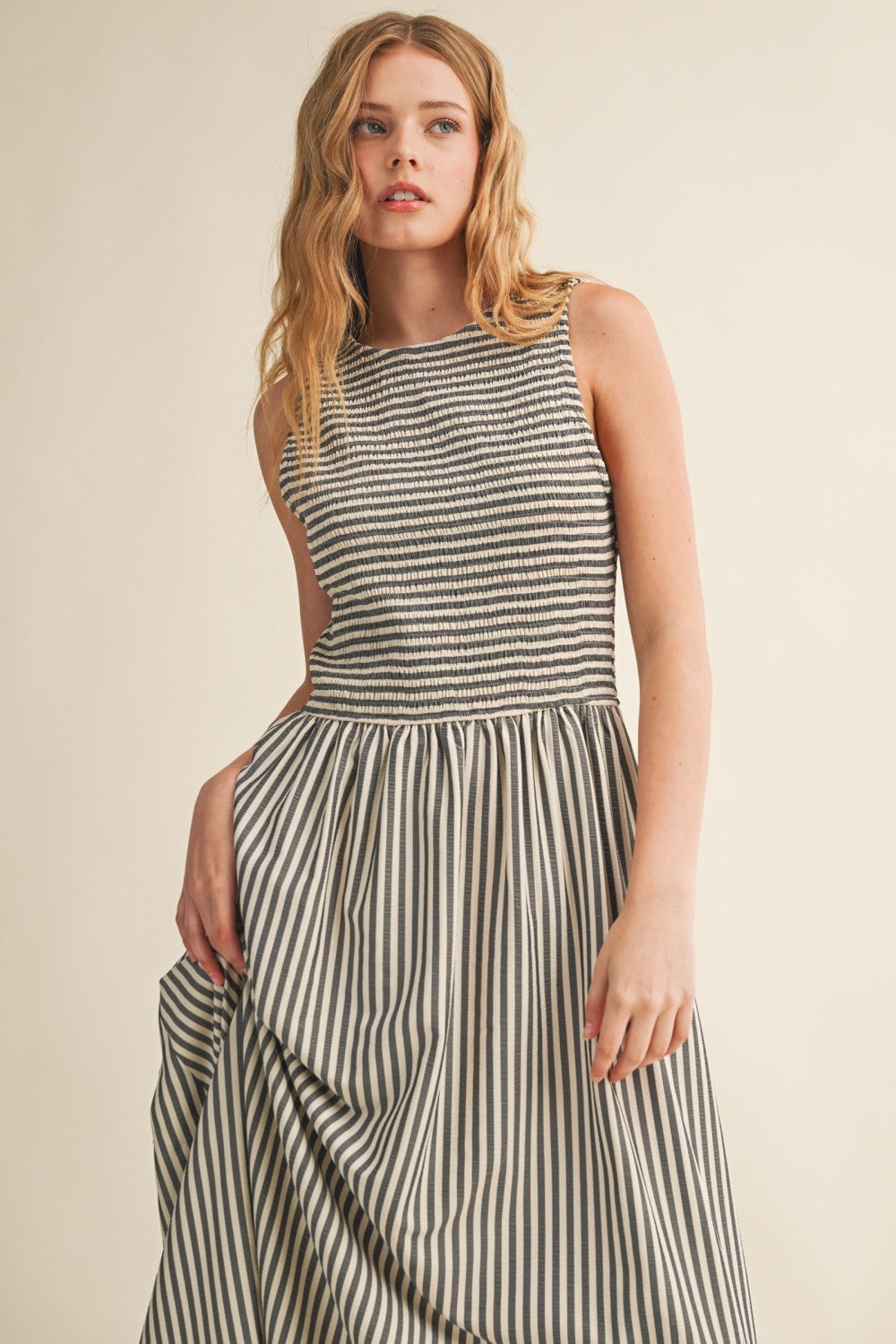 Close-up of Darcy Smocked Stripe Maxi Dress in black, featuring a textured smocked bodice, sleeveless design, and flowing striped maxi skirt.