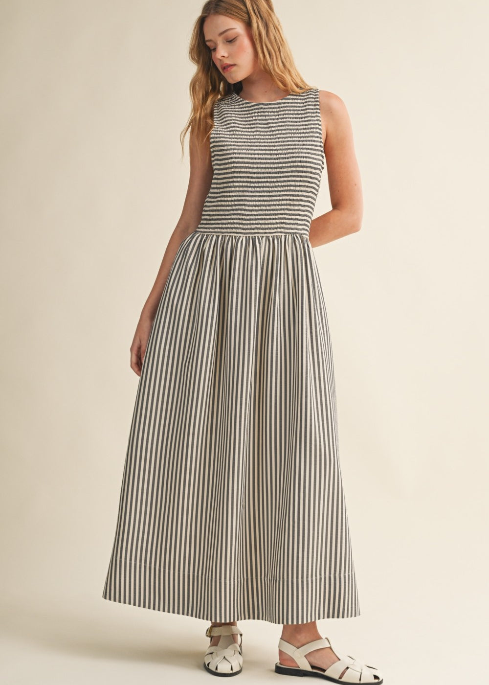 Darcy Smocked Stripe Maxi Dress in black and ivory stripe, full-length front view with sleeveless smocked bodice and side pockets.