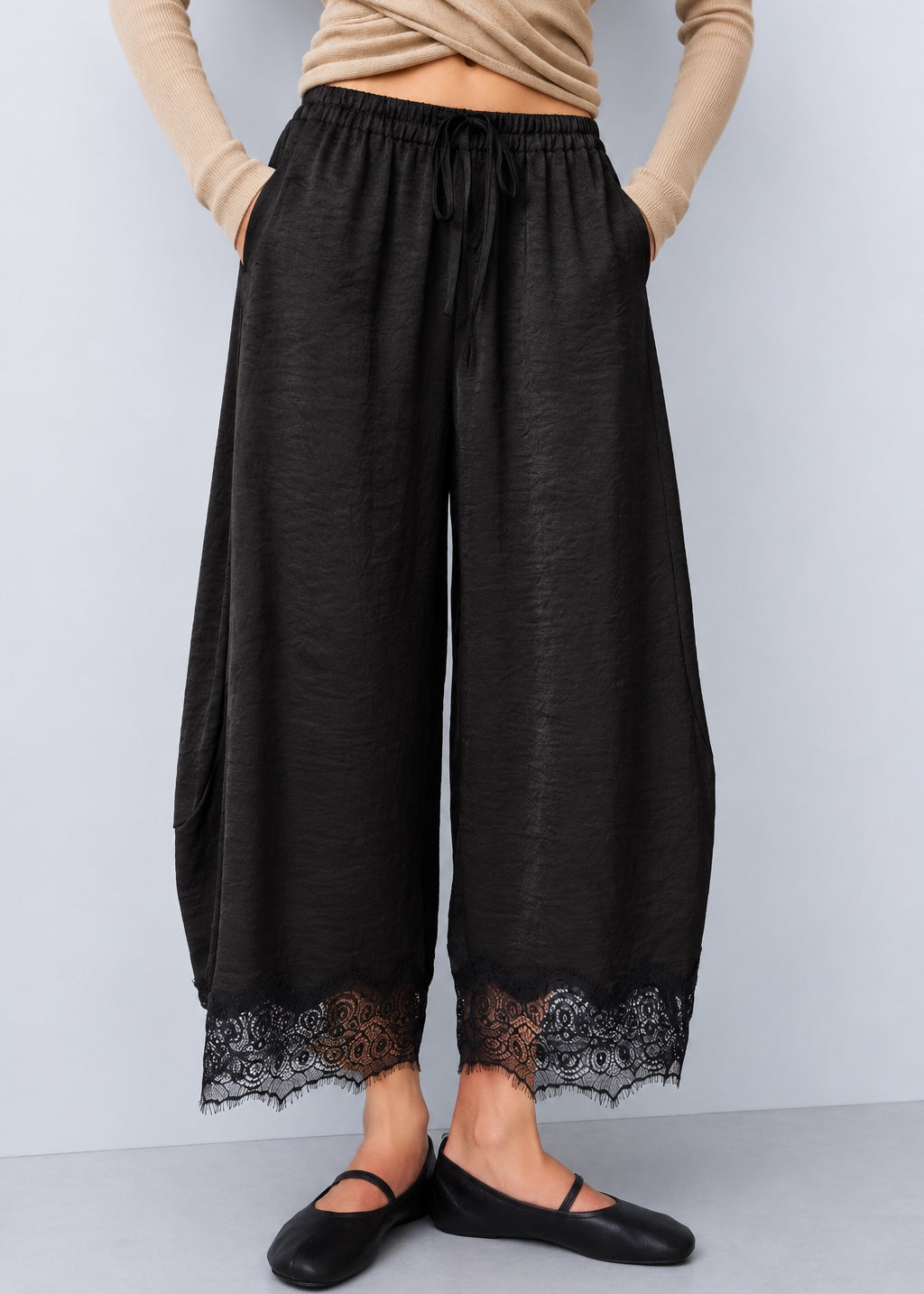 Front view of Daydream black lace-trim satin barrel pants styled with a beige top and ballet flats