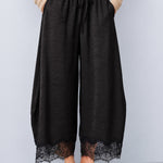 Front view of Daydream black lace-trim satin barrel pants styled with a beige top and ballet flats