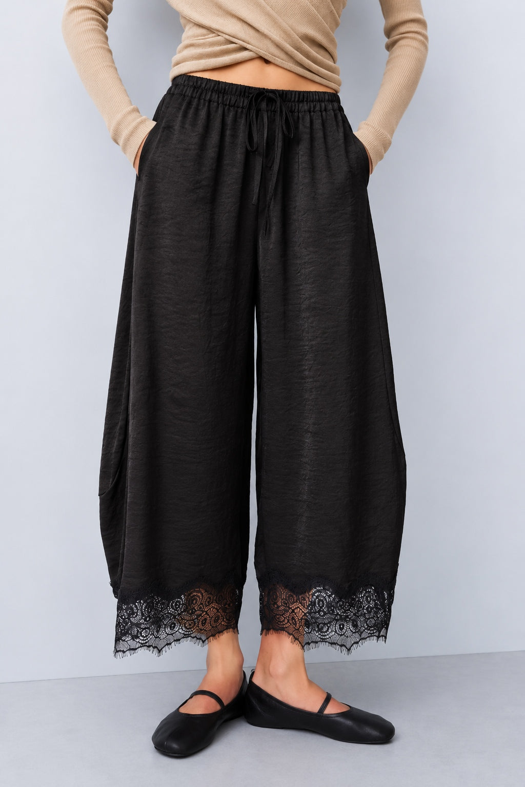 Front view of Daydream black lace-trim satin barrel pants styled with a beige top and ballet flats