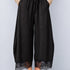 Front view of Daydream black lace-trim satin barrel pants styled with a beige top and ballet flats