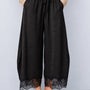Front view of Daydream black lace-trim satin barrel pants styled with a beige top and ballet flats