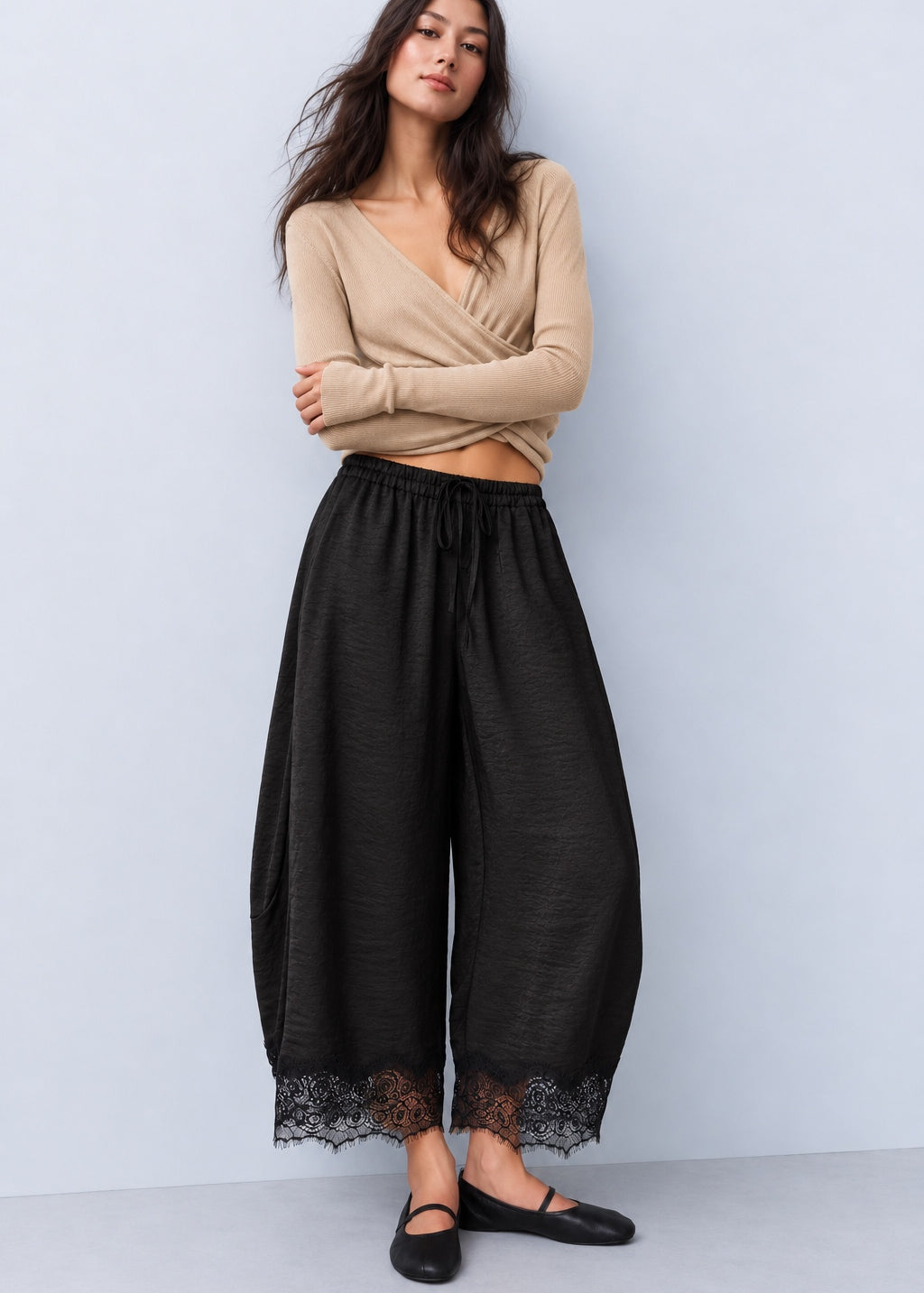 Model wearing Daydream black satin barrel pants with a beige sleeveless top and ballet flats