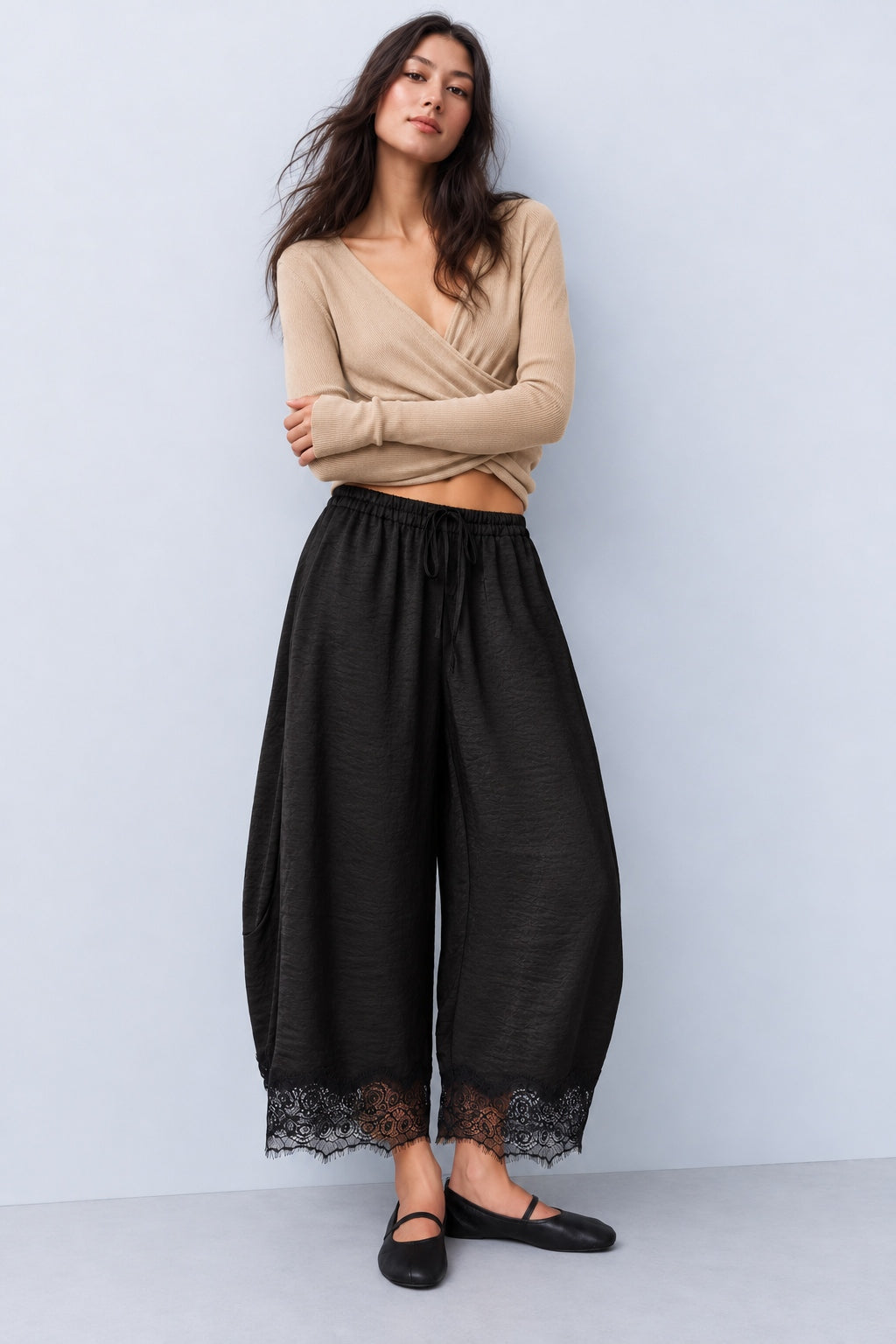 Model wearing Daydream black satin barrel pants with a beige sleeveless top and ballet flats