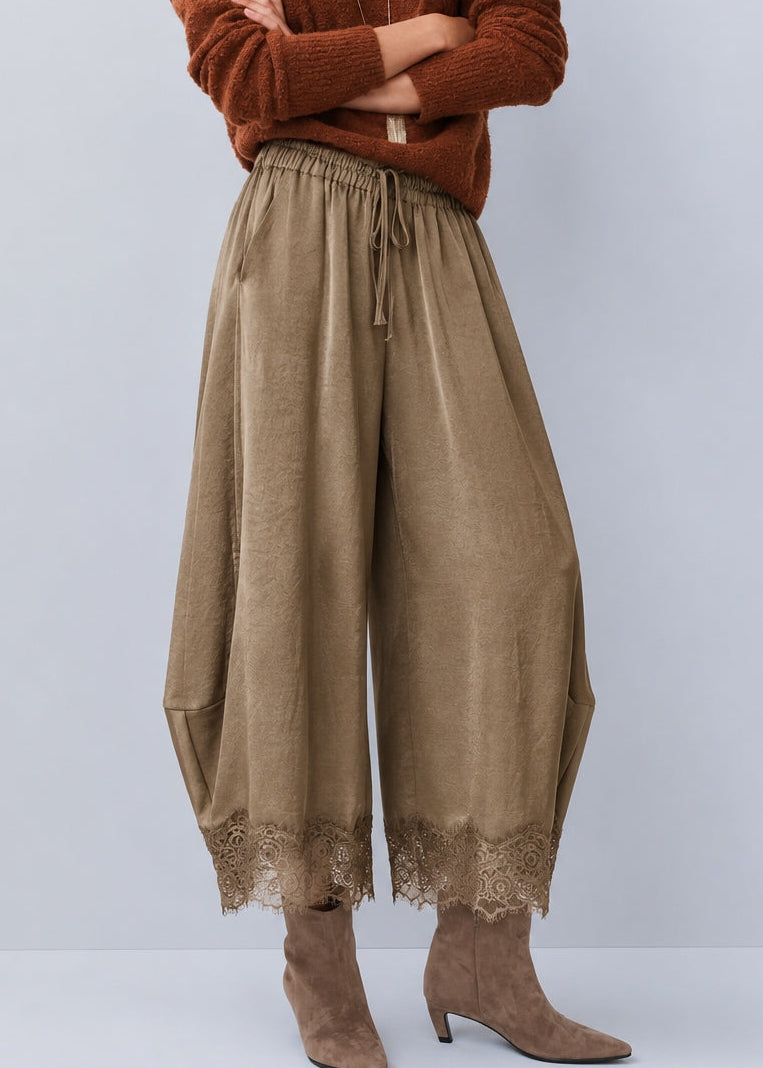 Front view of Daydream olive lace-trim satin barrel pants styled with a brown top and heels