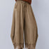 Front view of Daydream olive lace-trim satin barrel pants styled with a brown top and heels