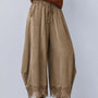 Front view of Daydream olive lace-trim satin barrel pants styled with a brown top and heels