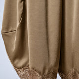 Close-up of the olive satin fabric and delicate lace-trimmed hems on Daydream barrel pants