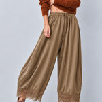 Daydream olive lace-trim satin pants paired with a fitted brown top and heels