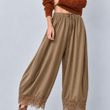 Daydream olive lace-trim satin pants paired with a fitted brown top and heels