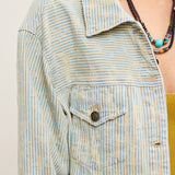 Close-up of striped denim fabric on distressed hem jacket in sand wash