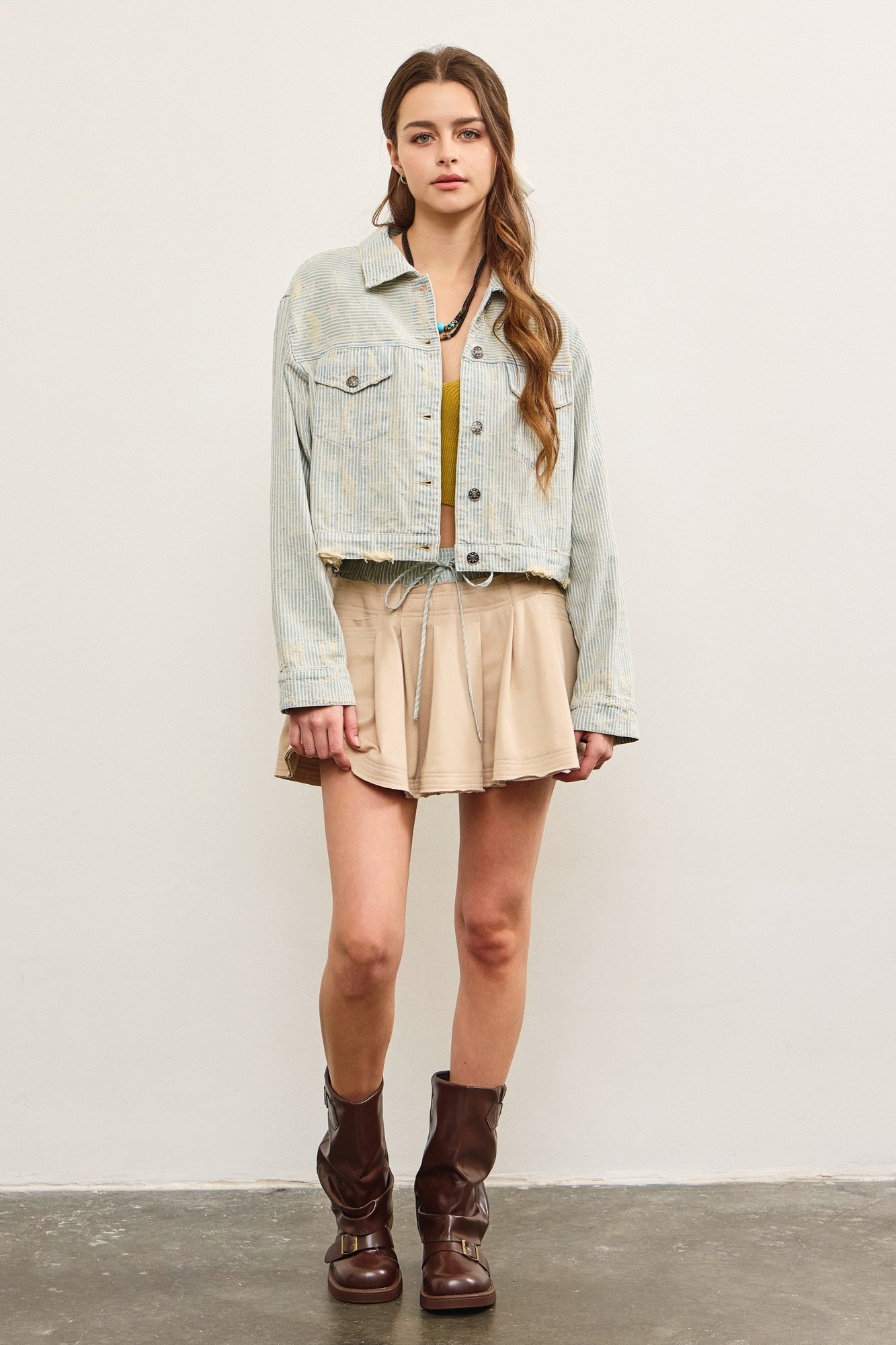 Full body view of distressed hem striped denim jacket styled with skirt