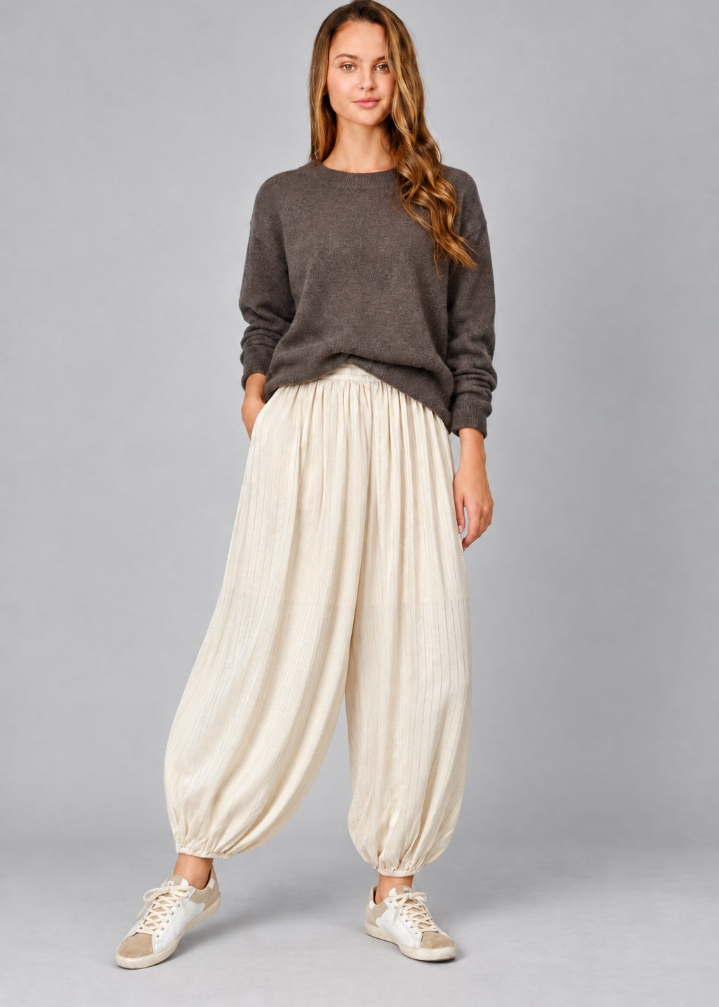 Front view of women’s beige striped satin balloon pants with a relaxed bubble-leg shape