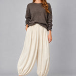 Front view of women’s beige striped satin balloon pants with a relaxed bubble-leg shape