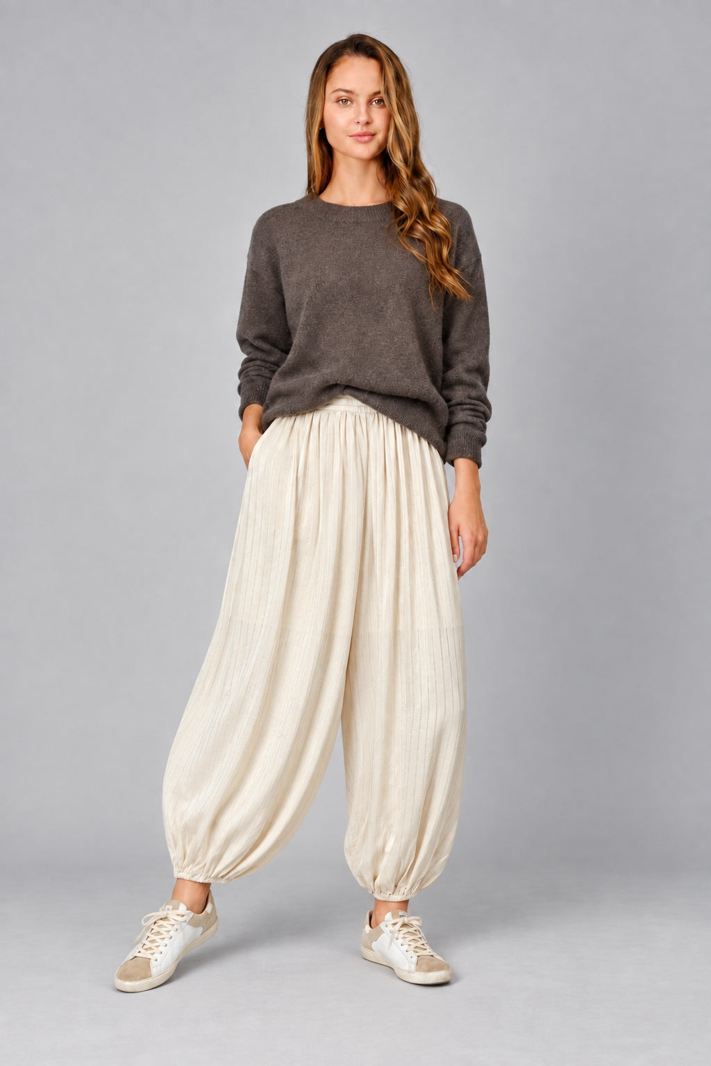 Front view of women’s beige striped satin balloon pants with a relaxed bubble-leg shape