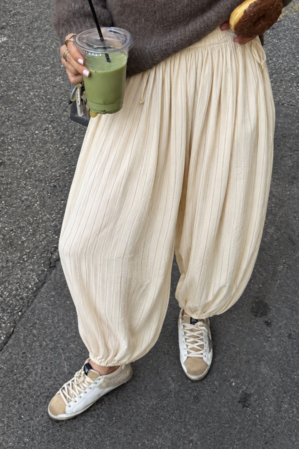 Woman styling the Double Bubble striped satin balloon pants in beige