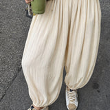 Woman styling the Double Bubble striped satin balloon pants in beige