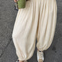 Woman styling the Double Bubble striped satin balloon pants in beige