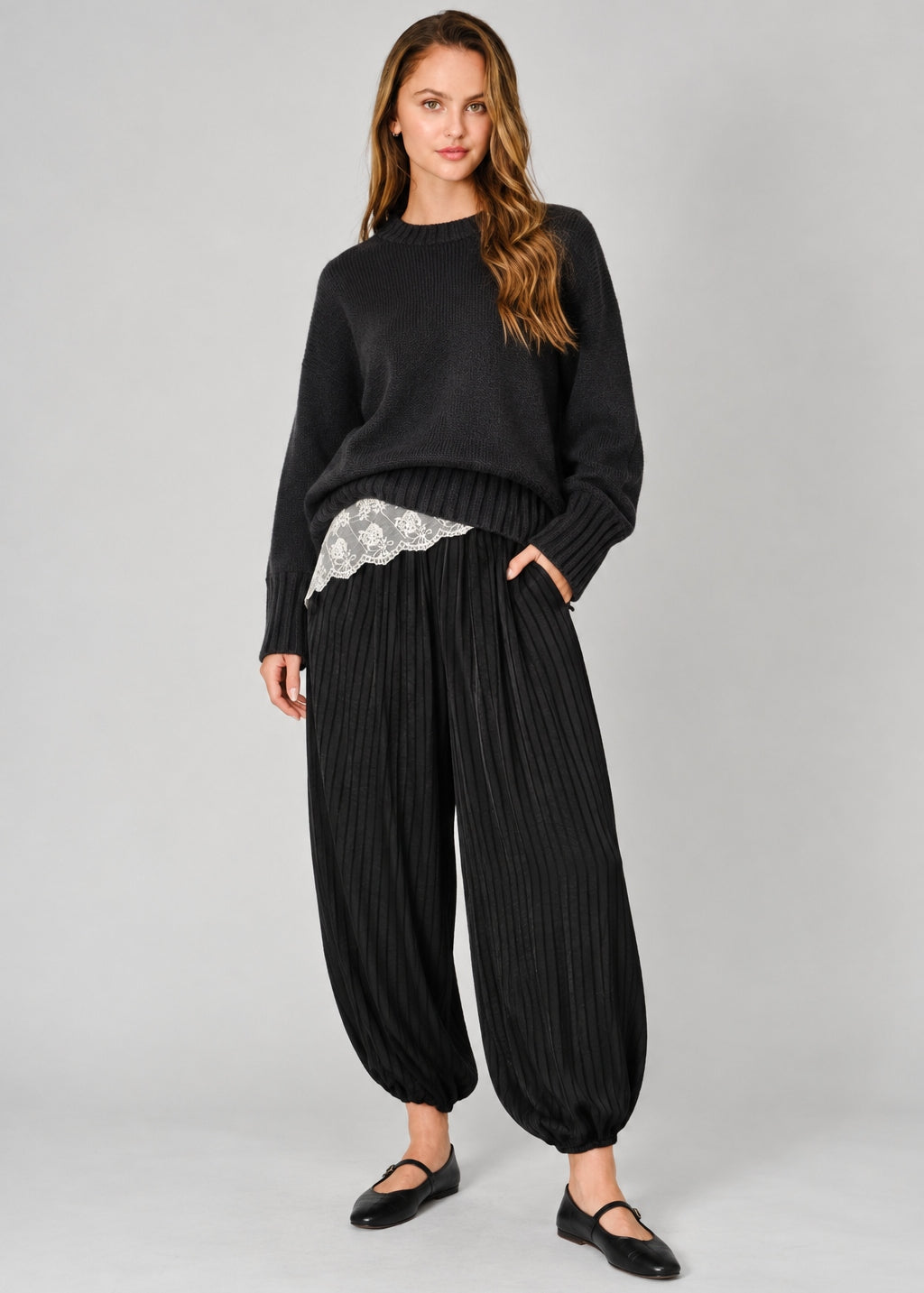 Front view of women’s black striped satin balloon harem pants with a relaxed bubble-leg shape