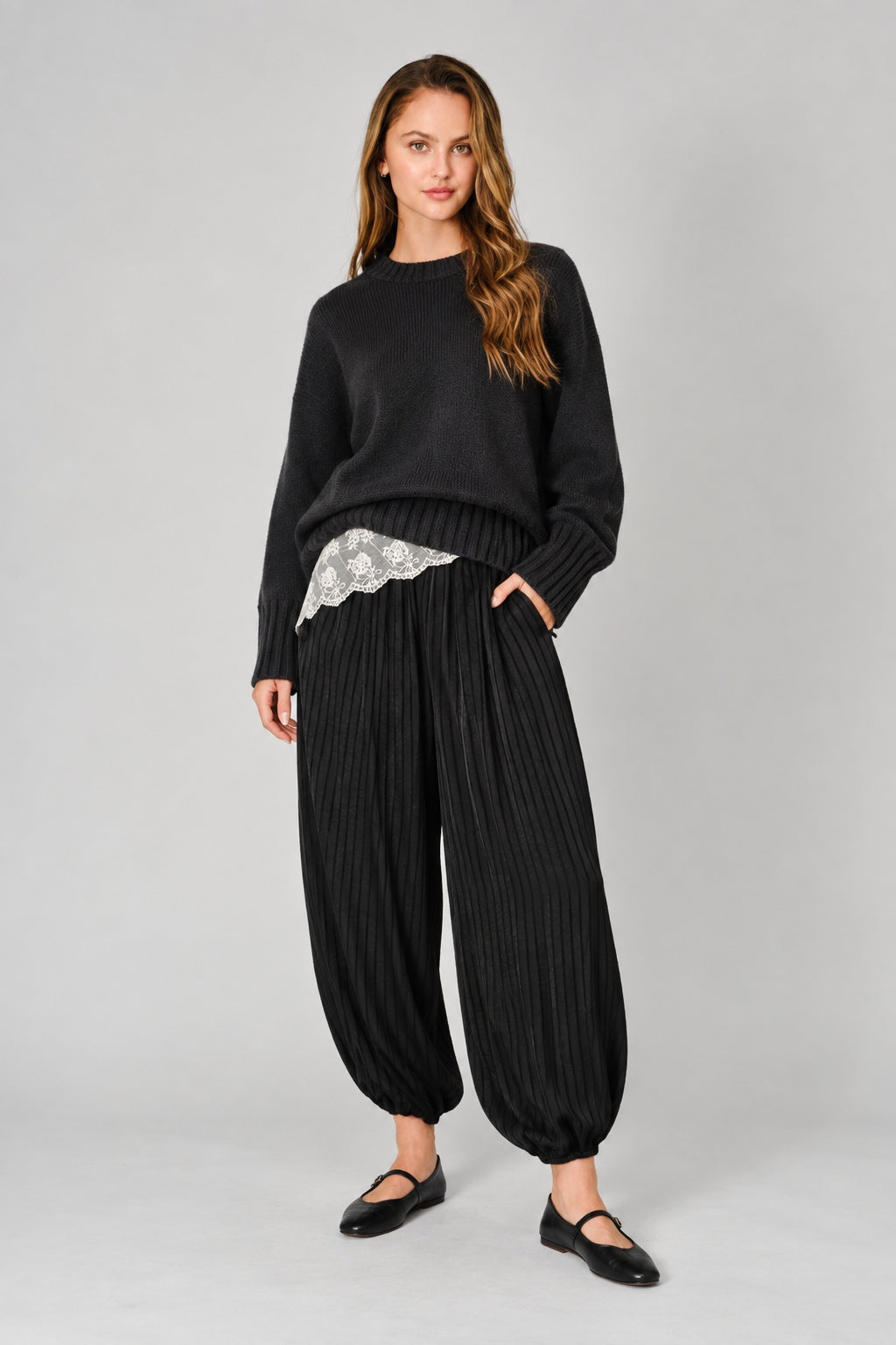 Front view of women’s black striped satin balloon harem pants with a relaxed bubble-leg shape