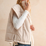 Side view of ecru bubble puffer vest showing high neckline, adjustable hem, and lightweight design.