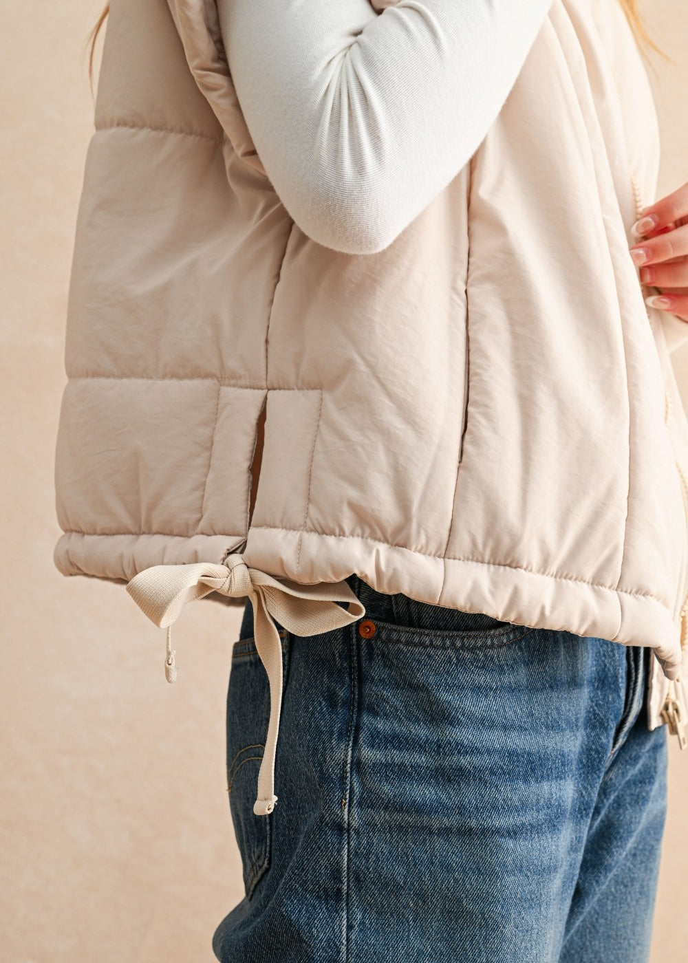 Back of ecru quilted puffer vest with longline silhouette and soft nylon texture — women’s winter vest.