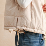 Back of ecru quilted puffer vest with longline silhouette and soft nylon texture — women’s winter vest.