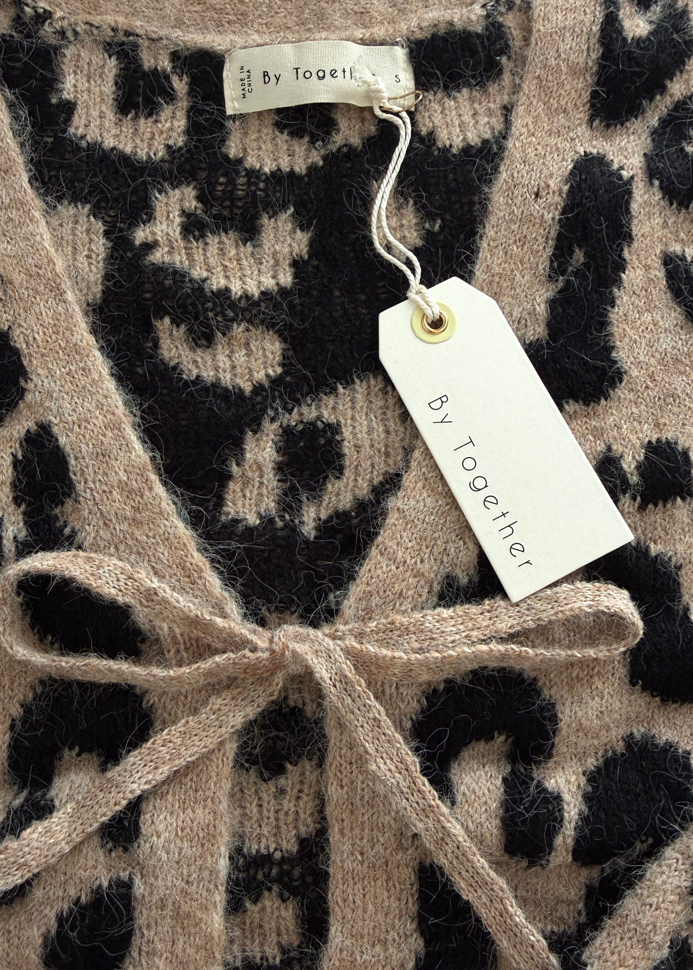 Close-up of Feline Leopard Print Tie Cardigan in mocha black showing knit texture, neckline, and tie detail